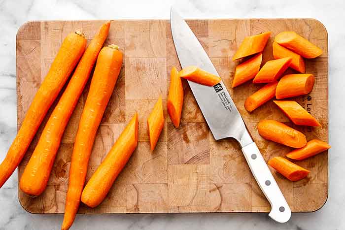 Chopping carrots on a board.