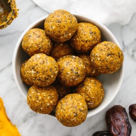 A bowl of mango energy balls next to dates and dried mangos.