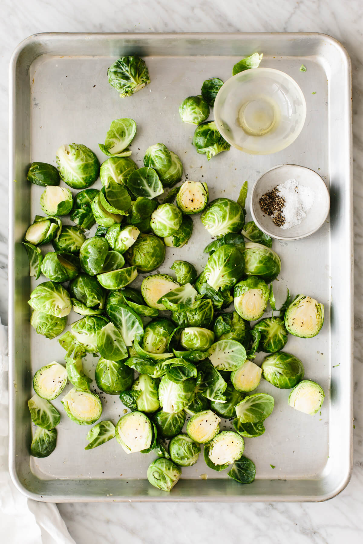 A sheet pan of Brussels sprouts before roasting.