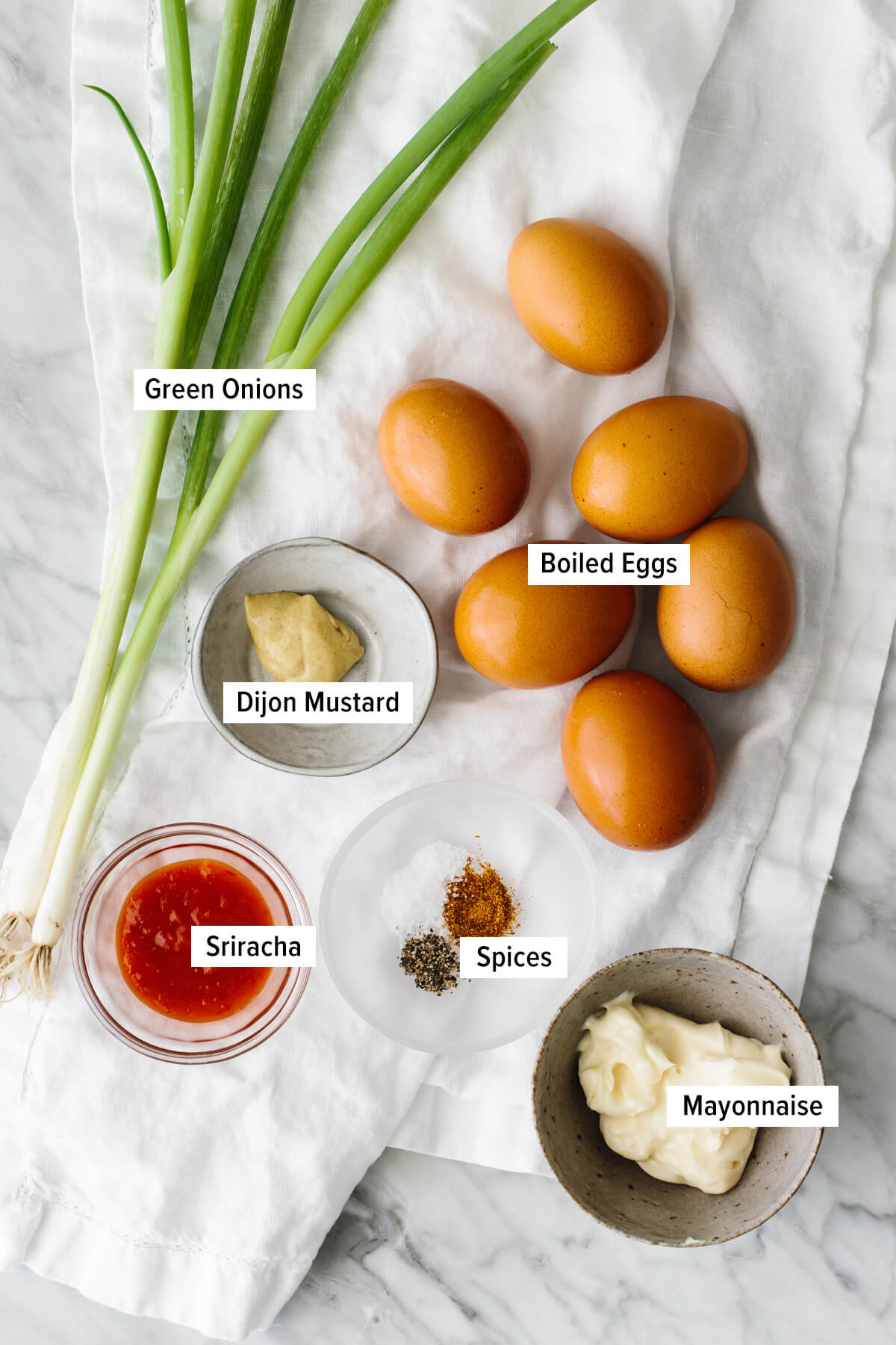 Ingredients for spicy deviled eggs laid out on a table.