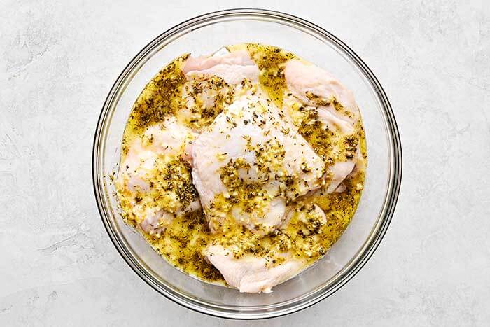 Marinating chicken thighs in a bowl.