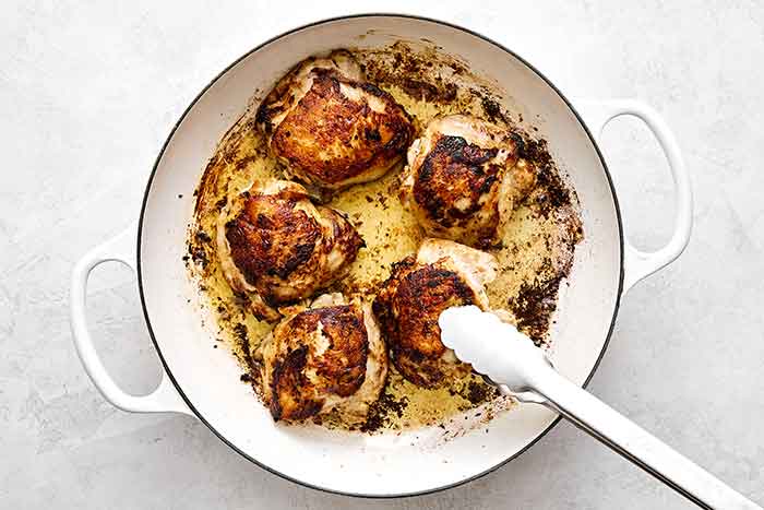 Cooking chicken thighs in a pan.