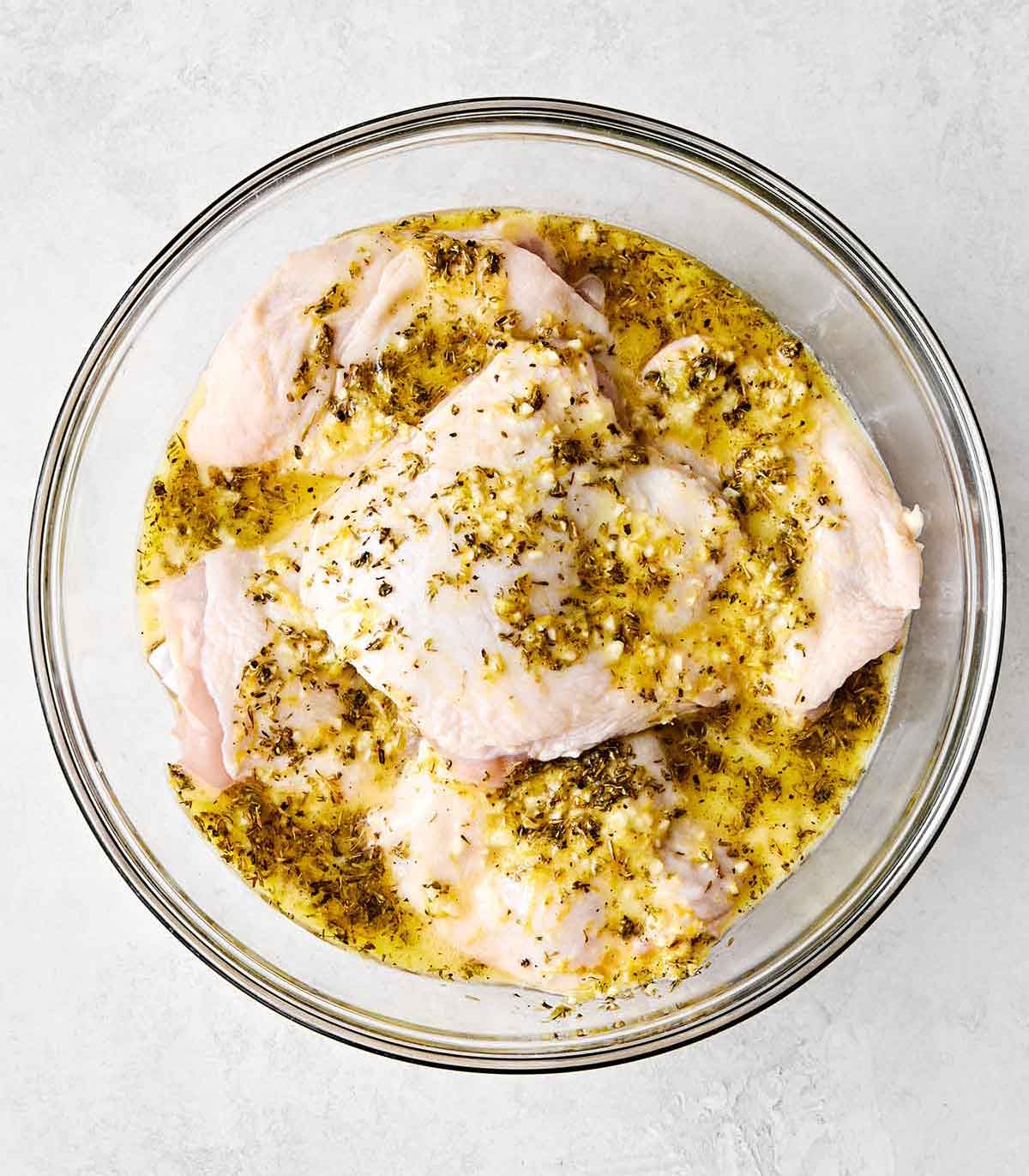 Marinating chicken thighs in a bowl.