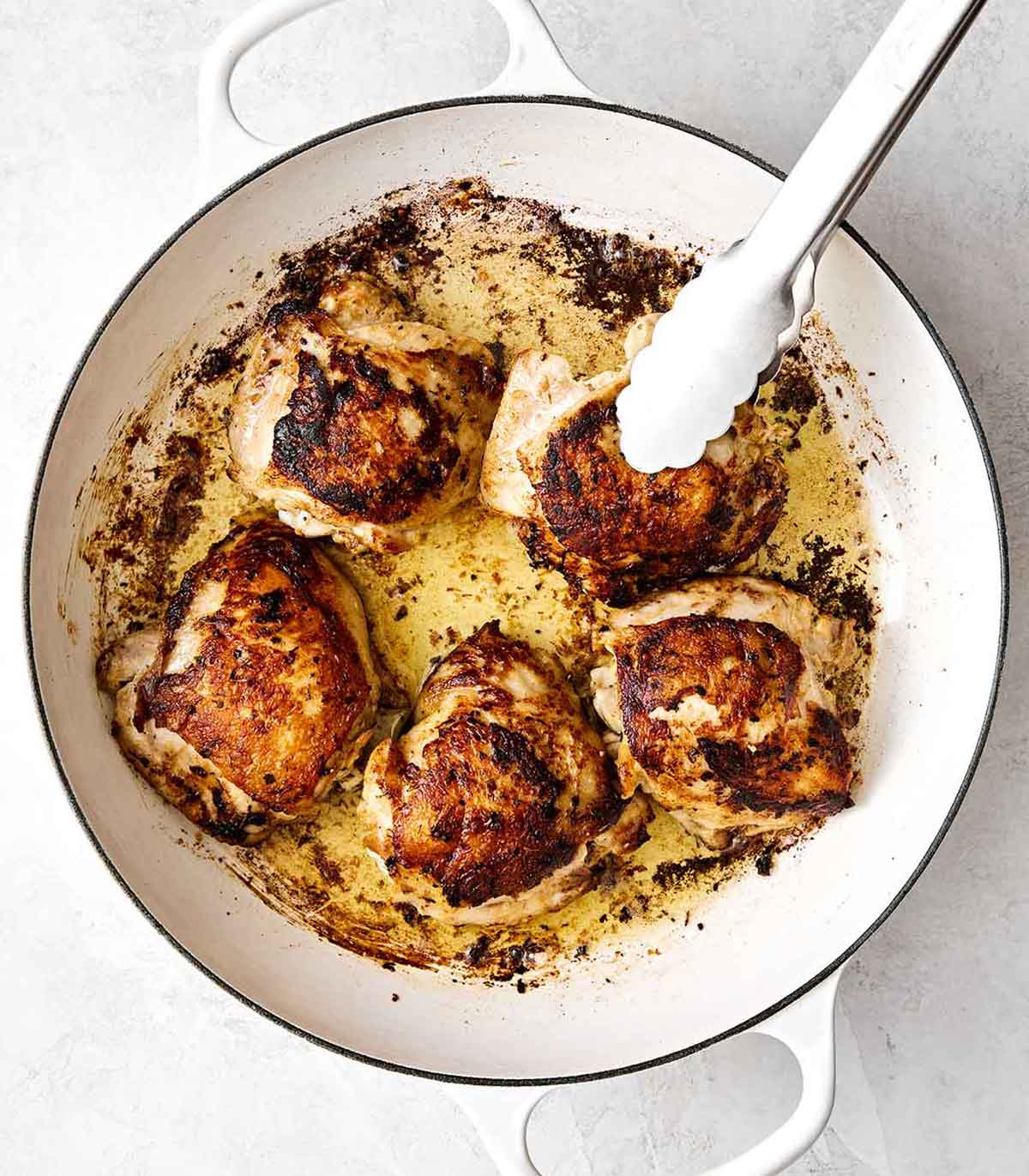 Cooking chicken thighs in a pan.