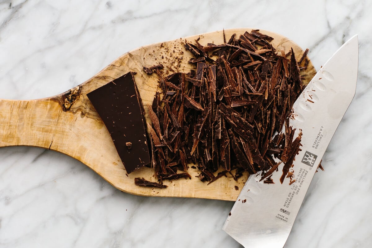 This is hands down the best hot chocolate you'll ever taste! It's unbelievably rich, velvety smooth, and perfect for warming up throughout the winter season. Chocolate shavings on a board for hot chocolate.