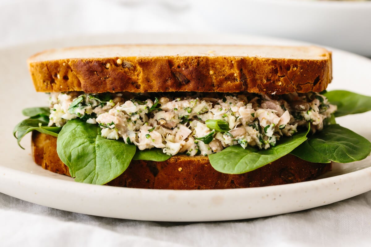 Broccoli tuna salad in a sandwich on a plate.