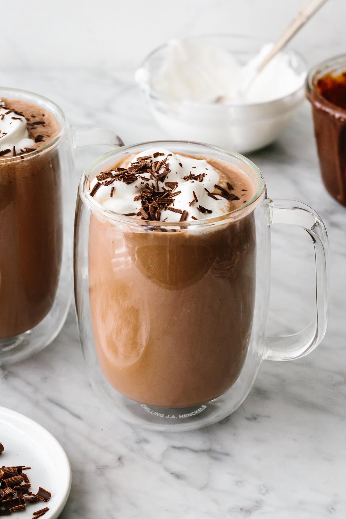 Nutella hot chocolate in a glass cup on a table.