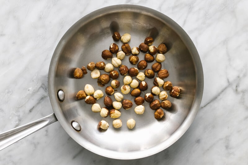 A pan toasting hazelnuts for romesco sauce