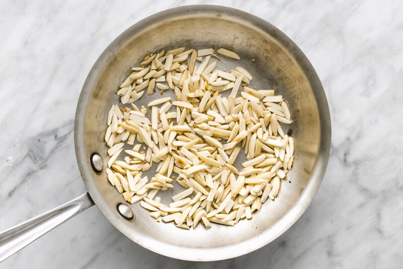 A pan toasting almonds for romesco sauce