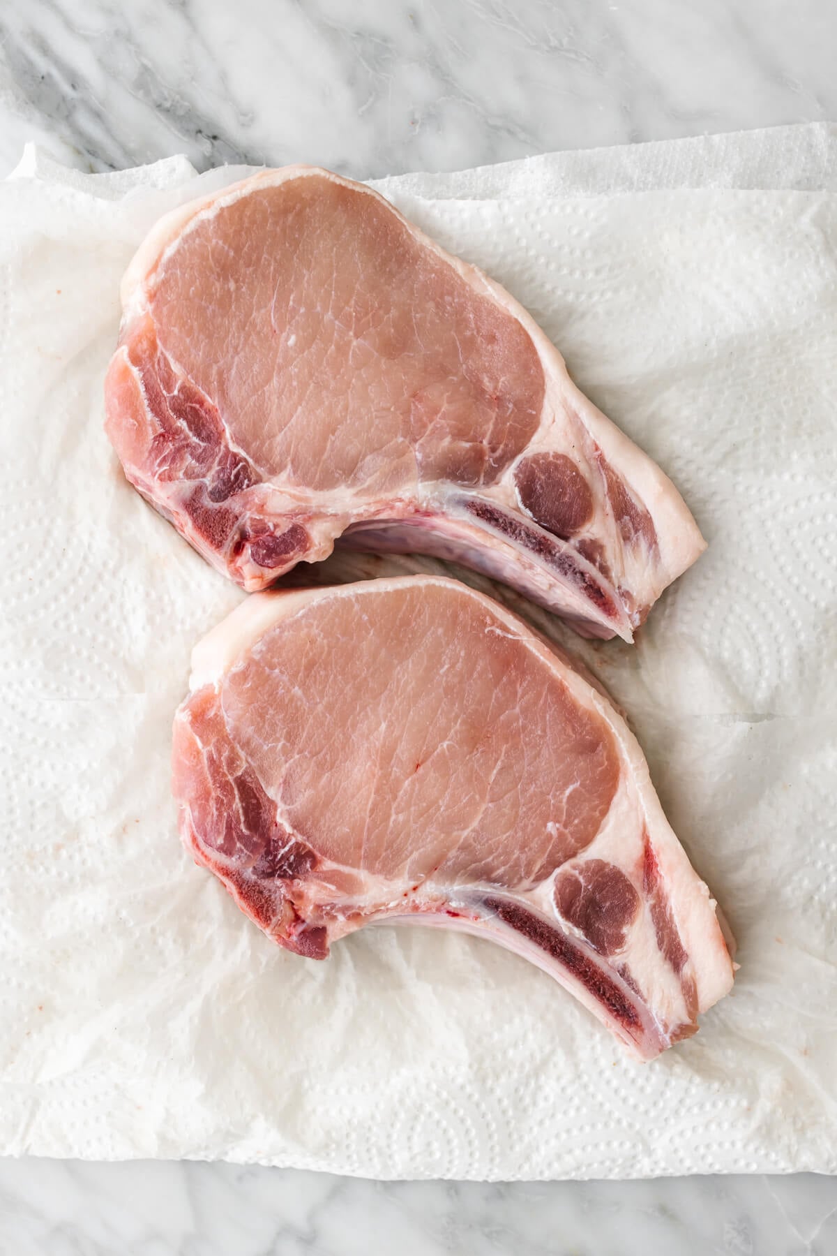 Prepping pork chops on a paper towel.