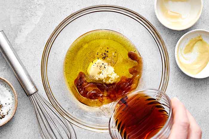 Mixing balsamic vinaigrette in a bowl.