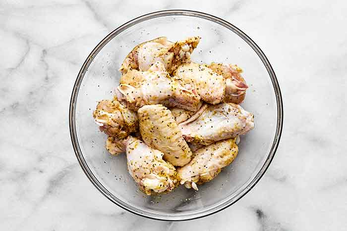 Step one of air fryer chicken wings: season the wings.