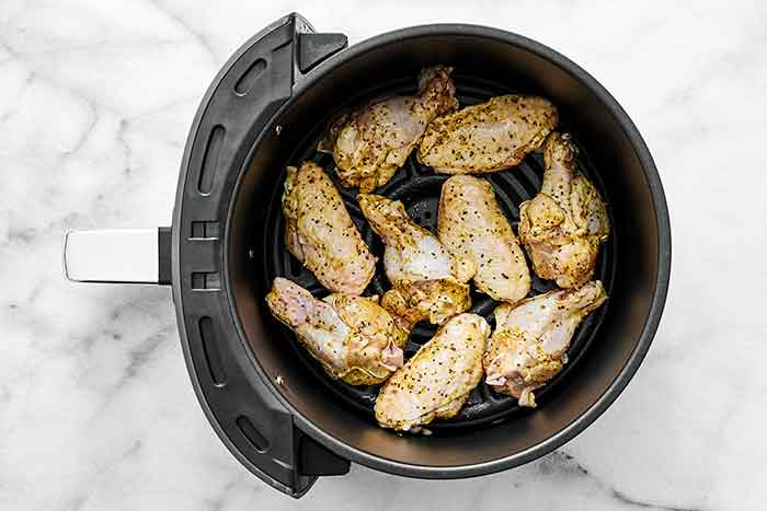 Step two of air fryer chicken wings: Air fry the wings.