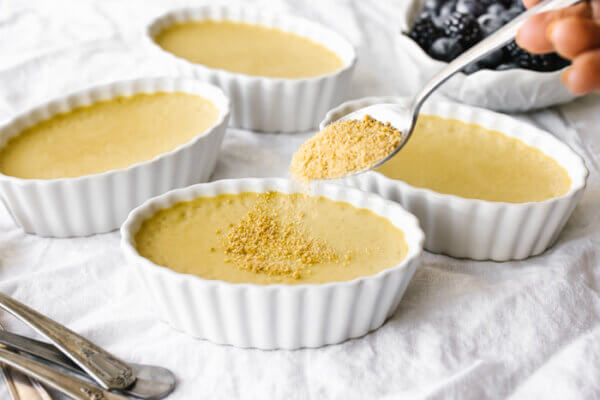 Adding maple sugar on top of a coconut crème brûlée