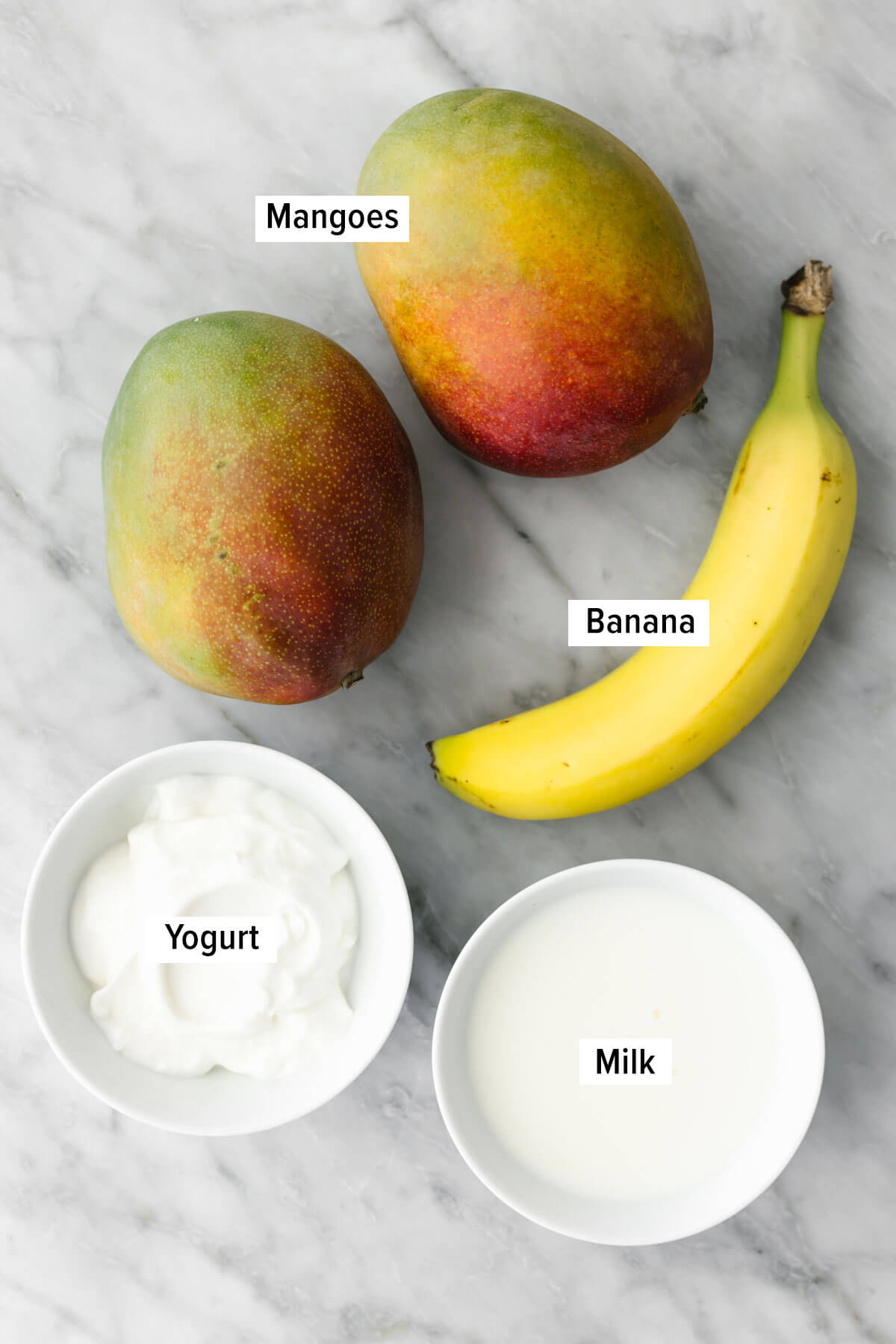 This creamy mango smoothie recipe is just the ultimate summer thirst quencher! Ingredients for mango smoothie on a table.