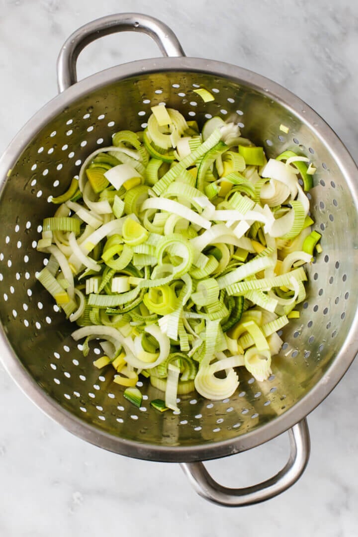 Washing leeks in a colander for potato leek soup