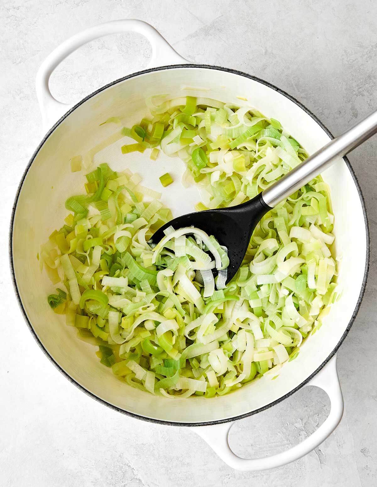 This potato leek soup is the ultimate fall soup! It's ultra-creamy, loaded with veggies, and completely vegetarian. Sauteing leeks in a pot.