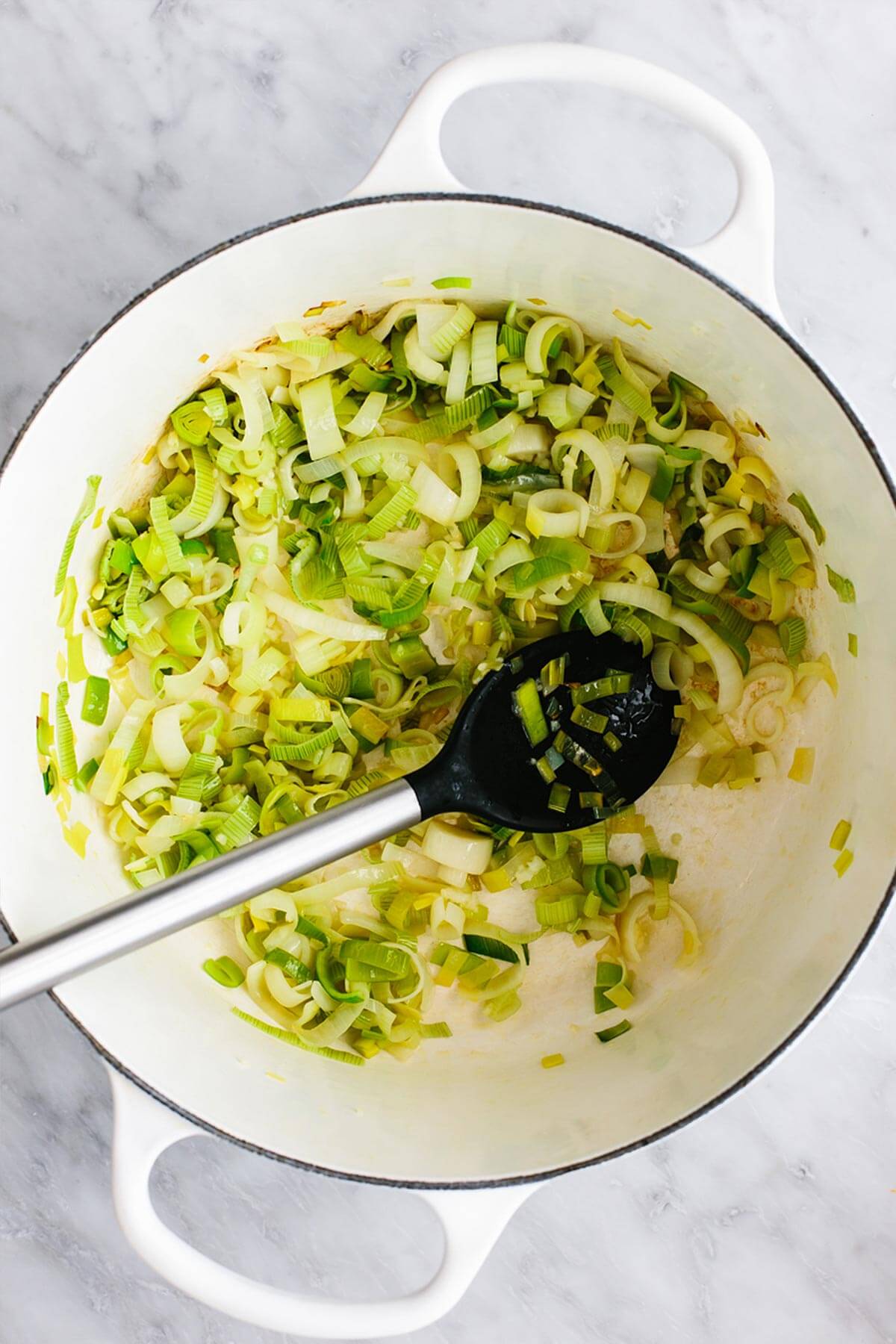 Cooking leeks and garlic in a pot.