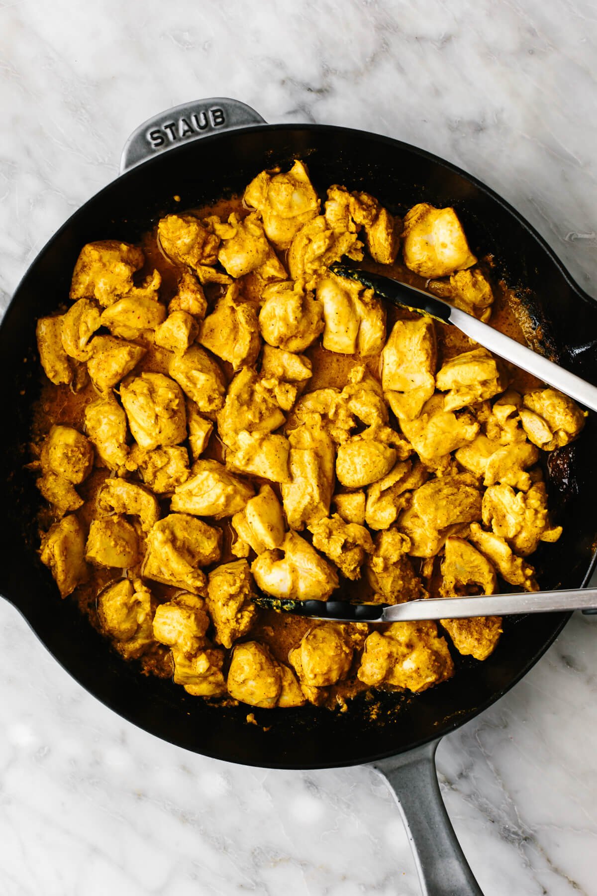 Cooking diced chicken in spices.