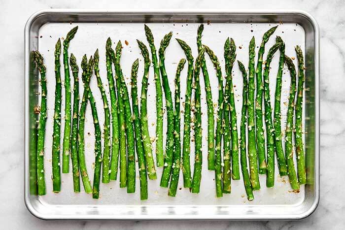 Finished roasted asparagus on a baking sheet.