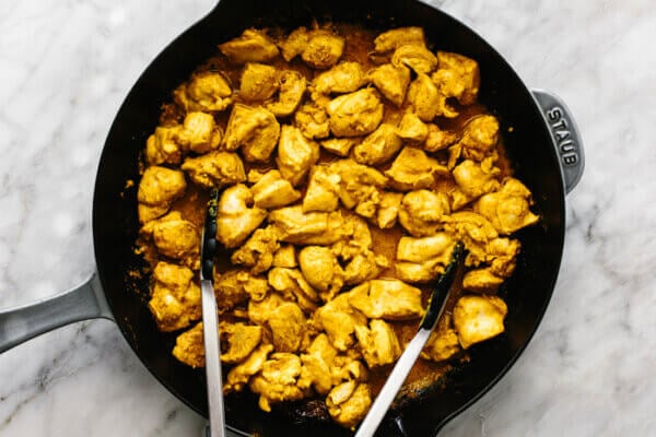 Cooked chicken pieces in a pan for butter chicken