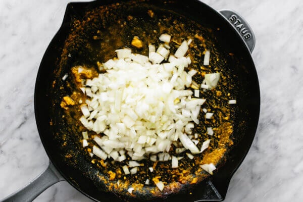 A pan with cooked onions for butter chicken