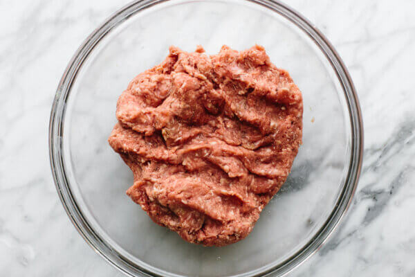 Mixing burger patty in a bowl for bacon guacamole burger bites