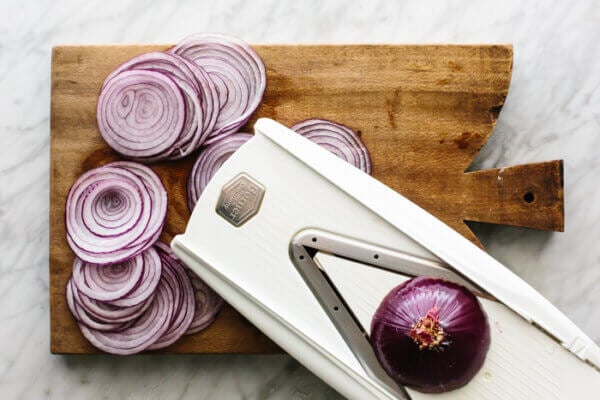 Slicing red onions with a mandoline for pickled red onions