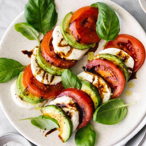 A platter of avocado caprese salad next to a napkin.