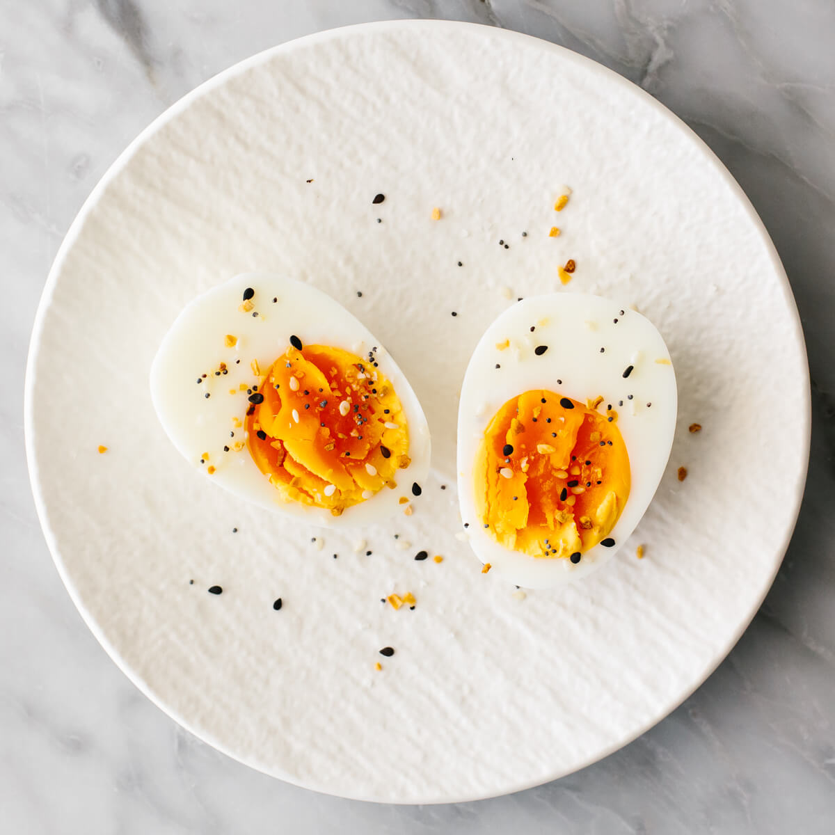 This budget meal prep shows that healthy eating doesn't have to break the bank. Turn 11 prepped ingredients into 7 meals that costs $3 or less! Boiled egg with seasoning on a plate