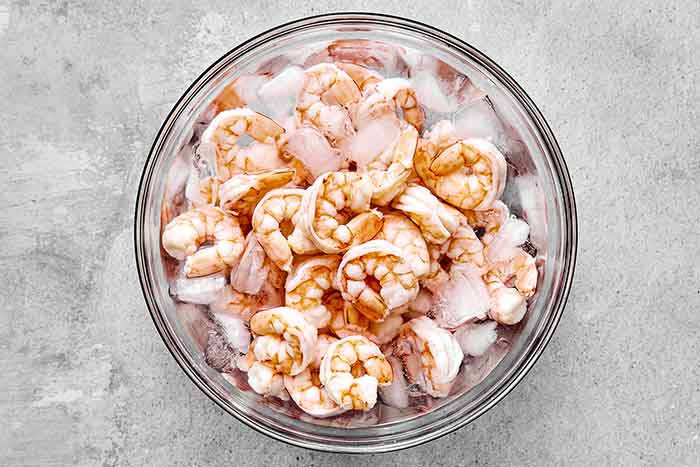 Chilling shrimp in a bowl of ice and water.