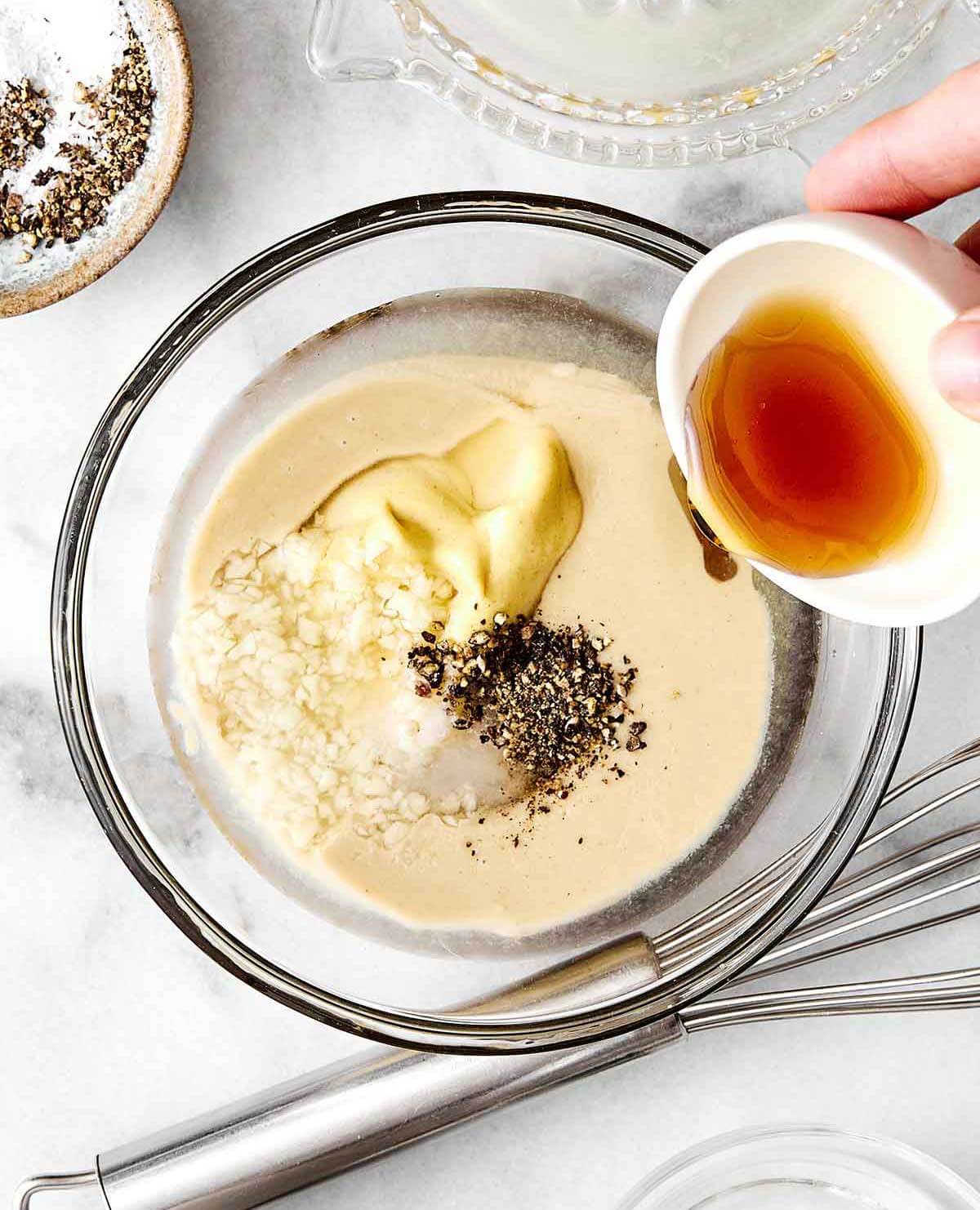 Step one of making a maple mustard tahini dressing—adding ingredients to a bowl.