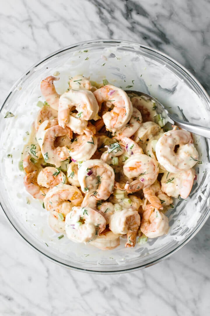 Mixing shrimp salad in a glass bowl