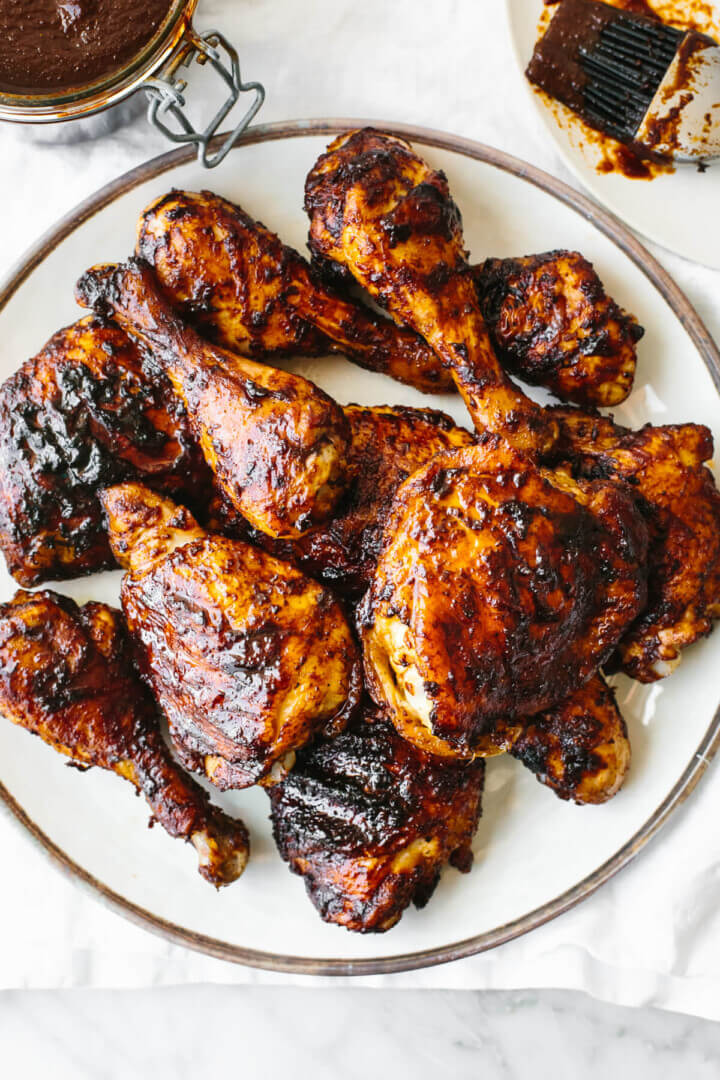A plate of BBQ chicken on a white plate and napkin.