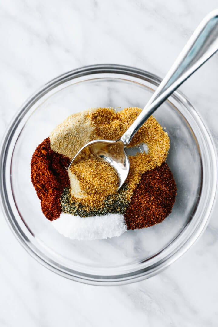 Stirring BBQ chicken dry rub in a bowl