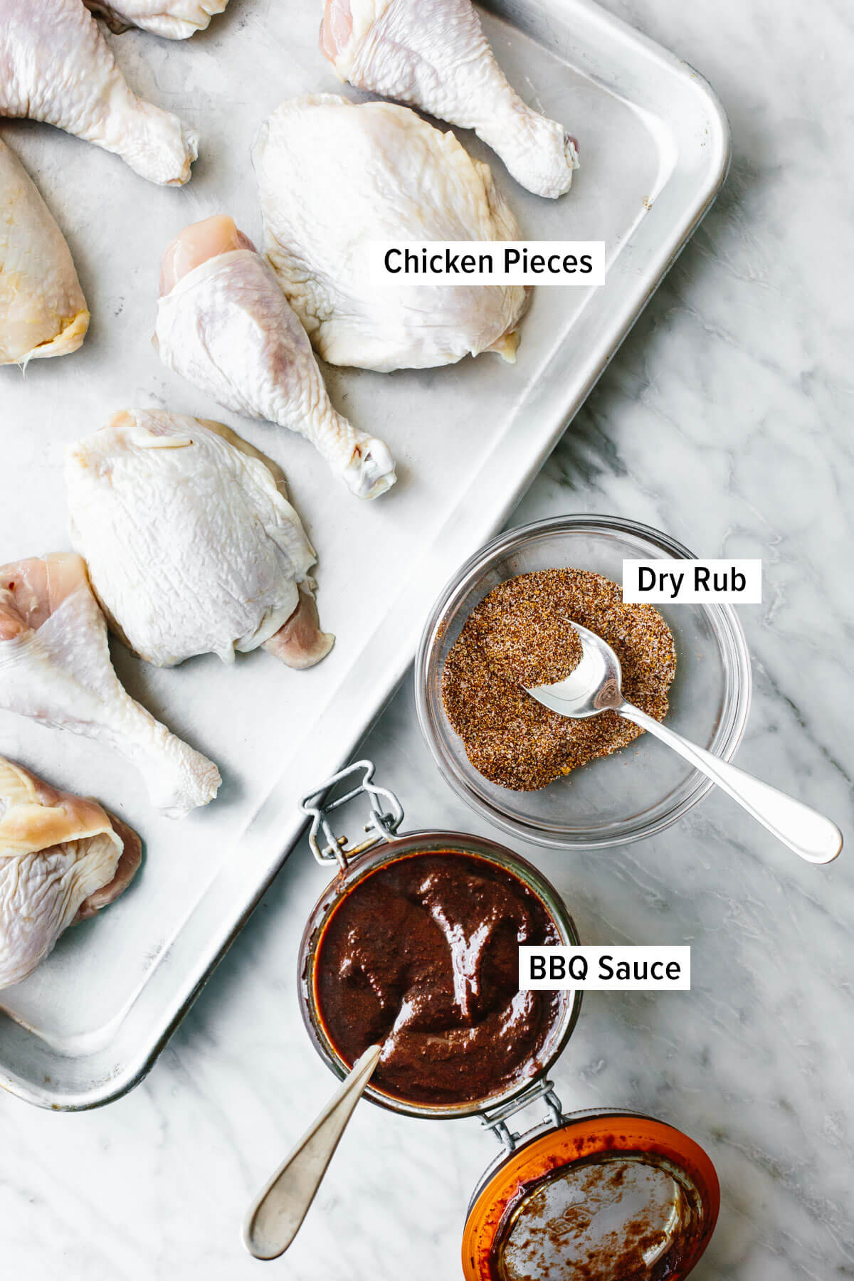 This BBQ chicken is insanely juicy, perfectly charred, and glistening with my secret homemade BBQ sauce. Perfect for your summer cookout! Ingredients for BBQ chicken on the table