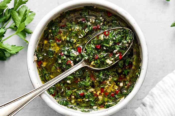 A bowl of fresh chimichurri sauce.