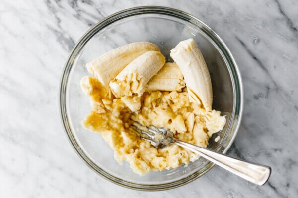 Mashing banana in a bowl to show how to freeze bananas