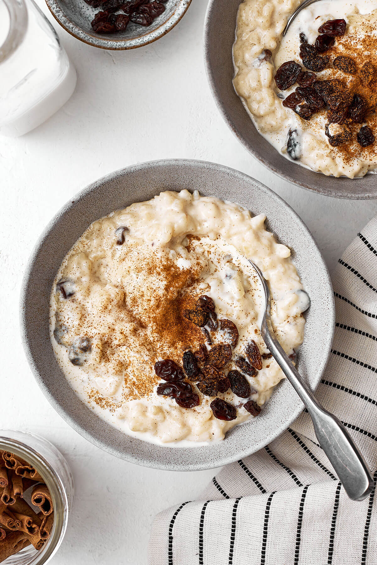 A spoon with rice pudding in a bowl