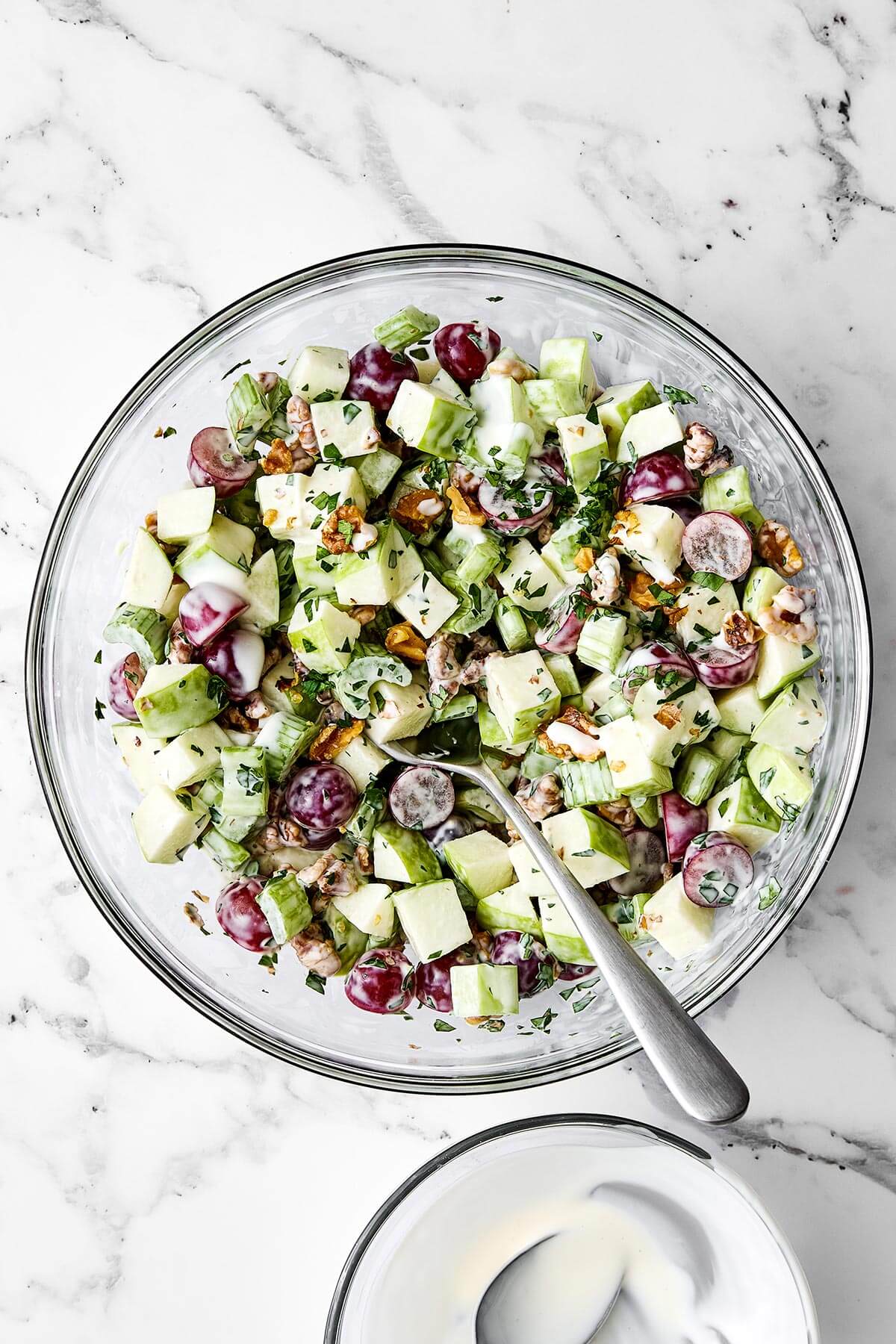 Everyone will love this classic Waldorf salad for holiday dinners! It's crisp, refreshing, and tossed in the best creamy dressing. Waldorf salad in a glass bowl.