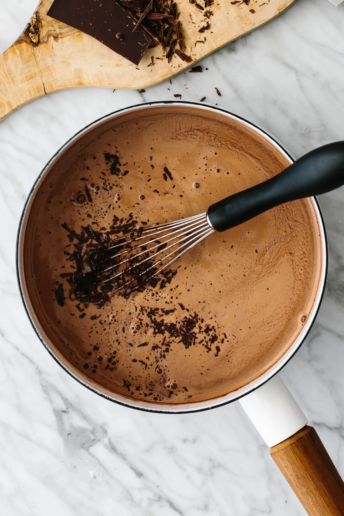 This is the best hot chocolate you'll ever taste! It's unbelievably rich, velvety smooth, and perfect for warming up through winter and Christmas. Mixing chocolate into warm milk.
