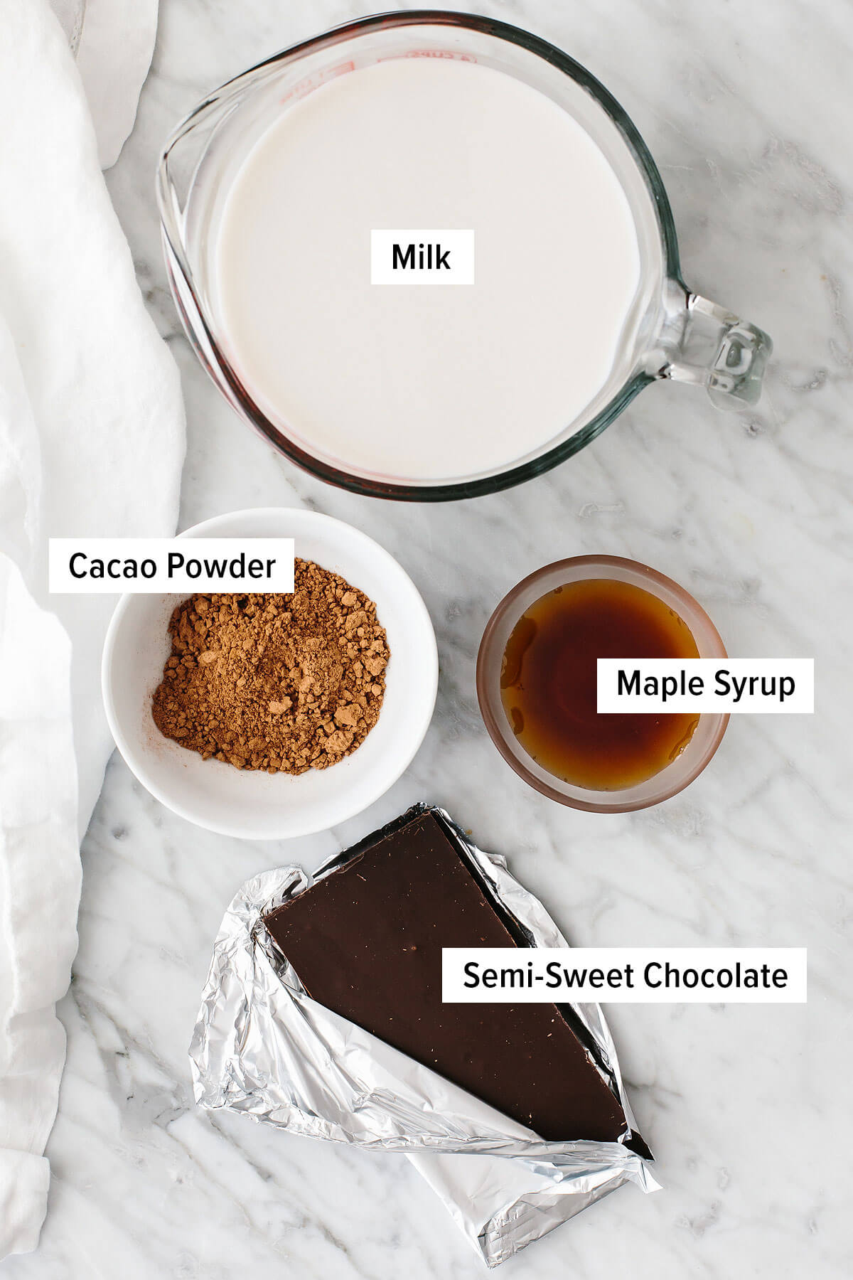 This is the best hot chocolate you'll ever taste! It's unbelievably rich, velvety smooth, and perfect for warming up through winter and Christmas. Ingredients for hot chocolate on a table.