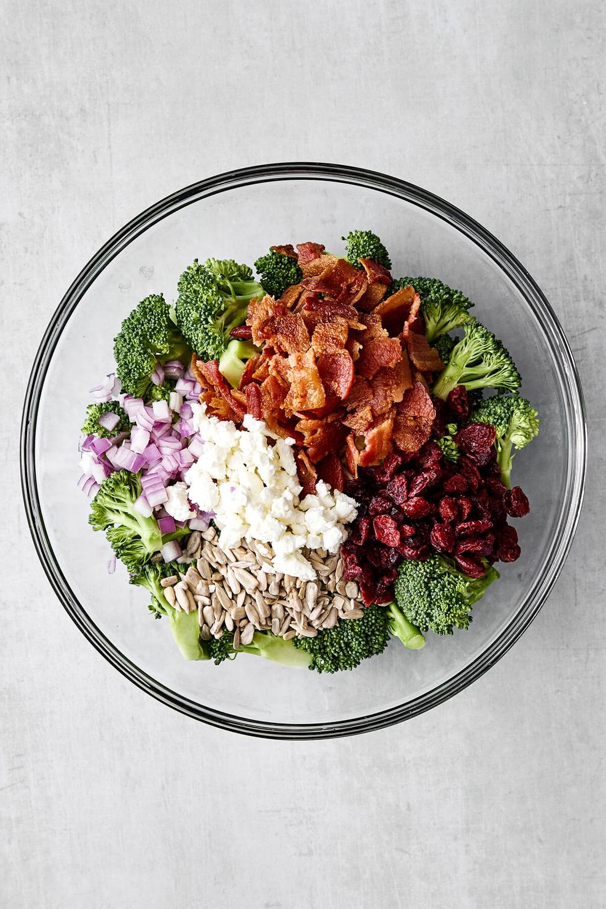 Everyone loves this broccoli salad recipe! With bacon, cranberries, and a creamy dressing, it's the perfect party side dish. Broccoli salad in a glass bowl.