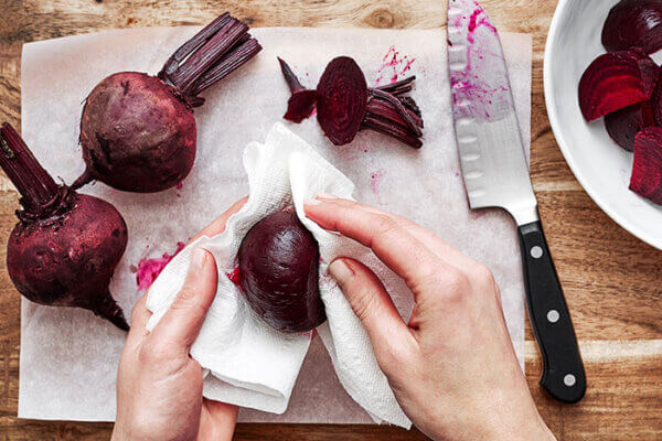 Wiping fresh roasted beets with a paper towel