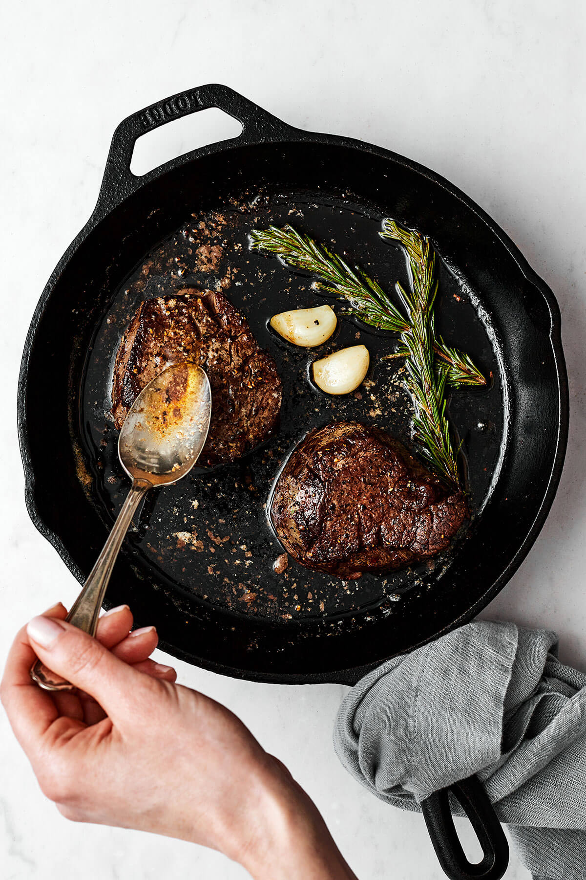 Basting butter over filet mignon steaks