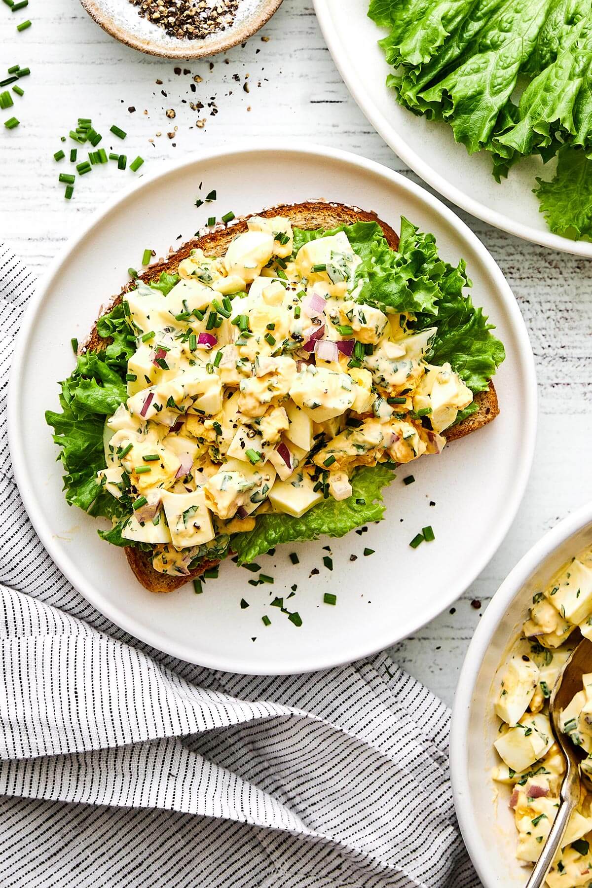 This is the classic deli-style egg salad we all know and love—perfectly creamy, delightfully chunky, and filled with fresh flavors. Egg salad on top of bread.