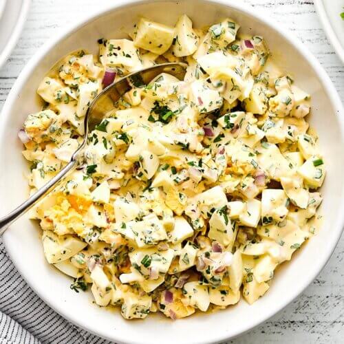 A white bowl of egg salad.