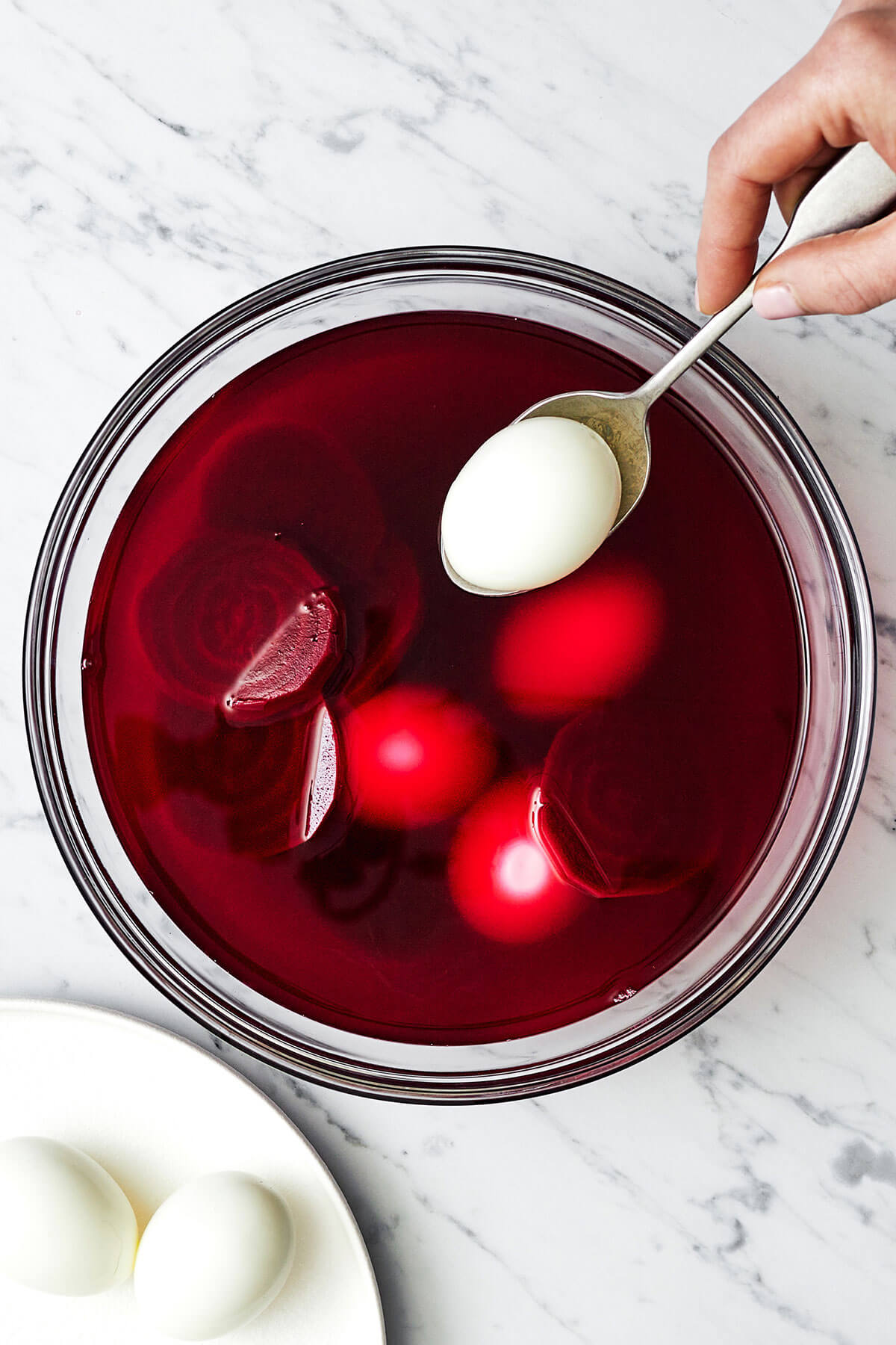 Adding eggs into beet mixture for beet pickled deviled eggs
