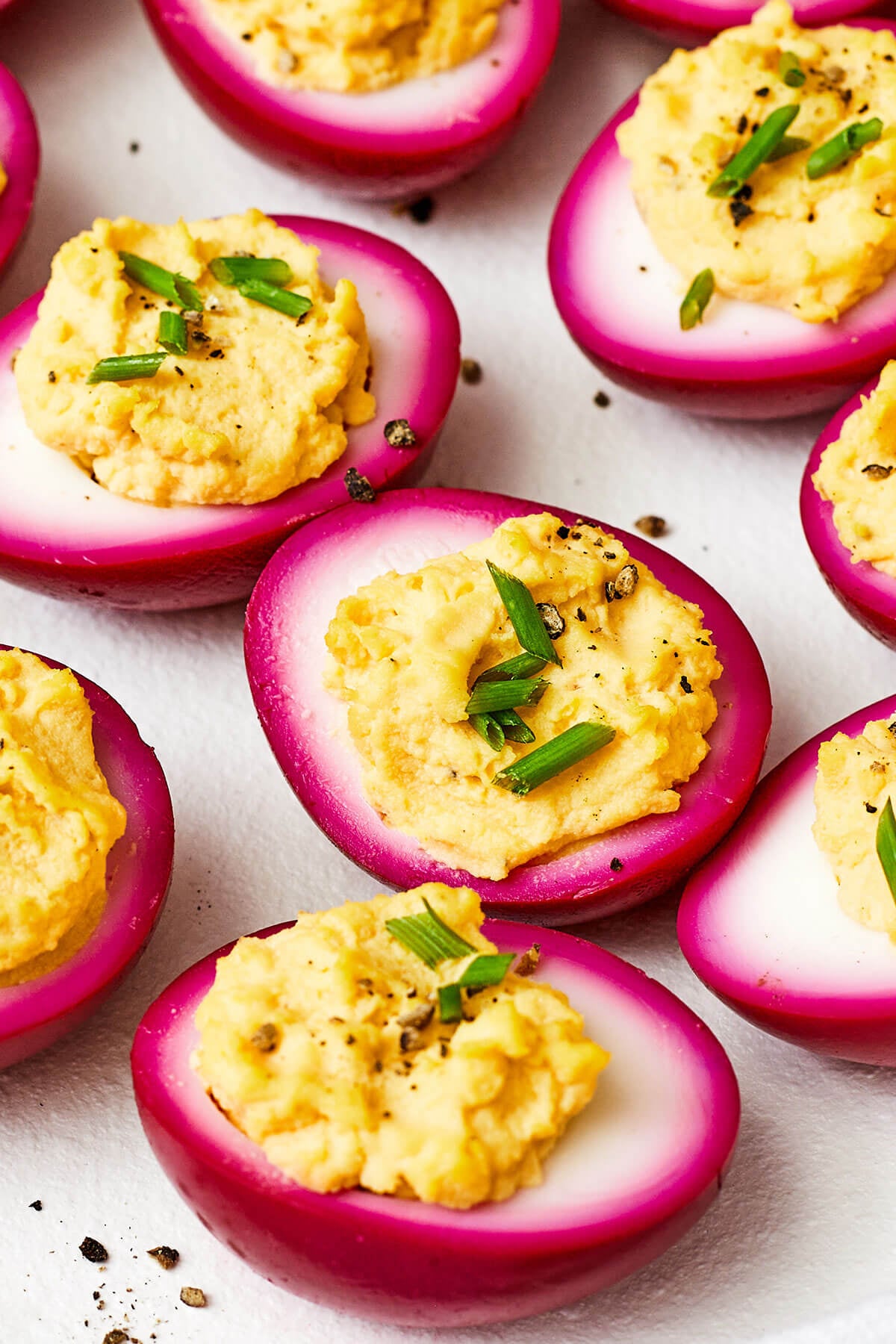 A white platter of beet pickled deviled eggs
