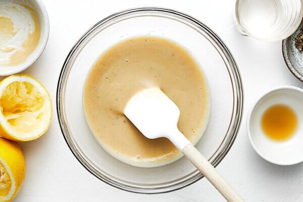 Mixing a lemon tahini dressing in a bowl